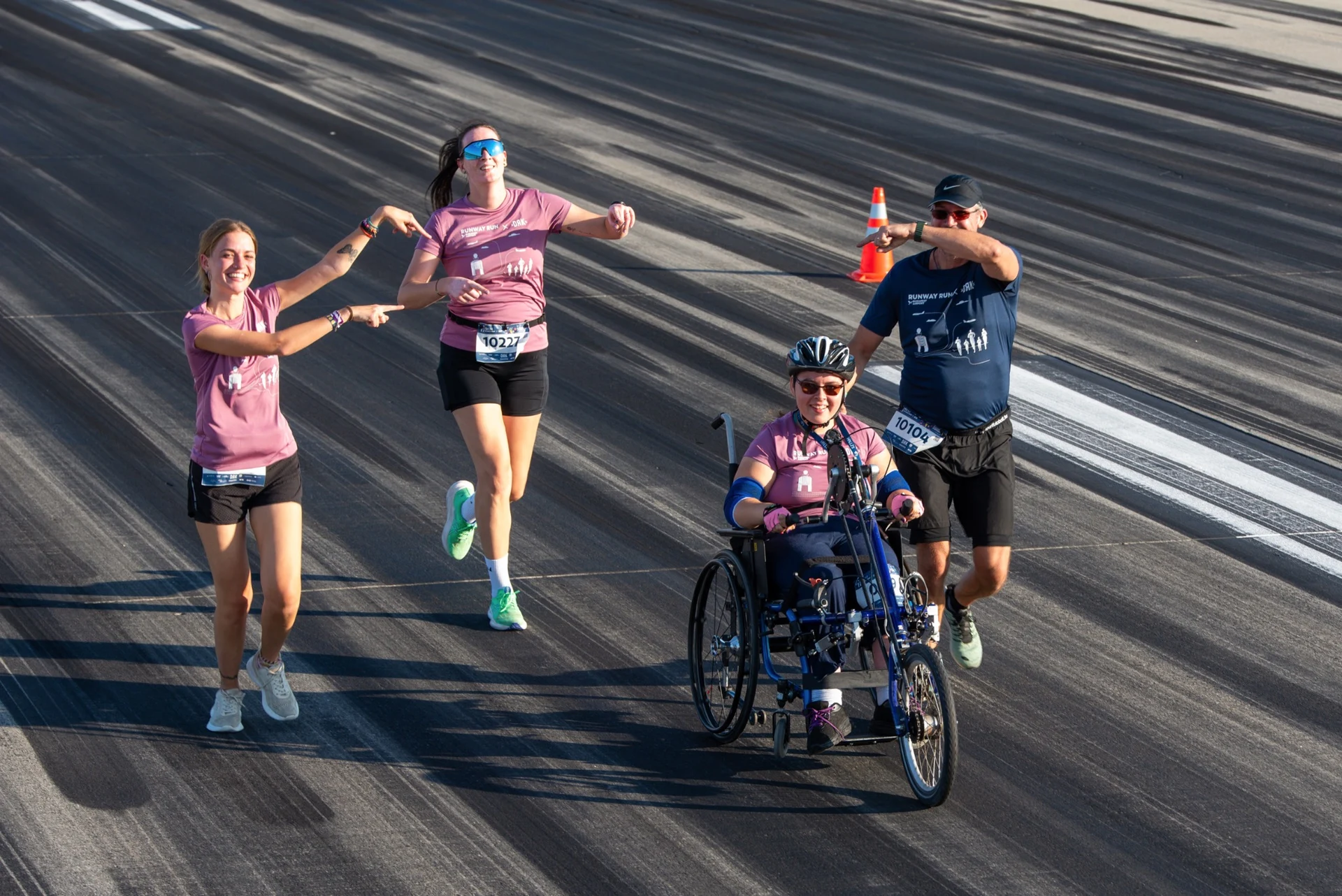 A társak a kézihajtású kerékpáron ülő parasportolót ünneplik