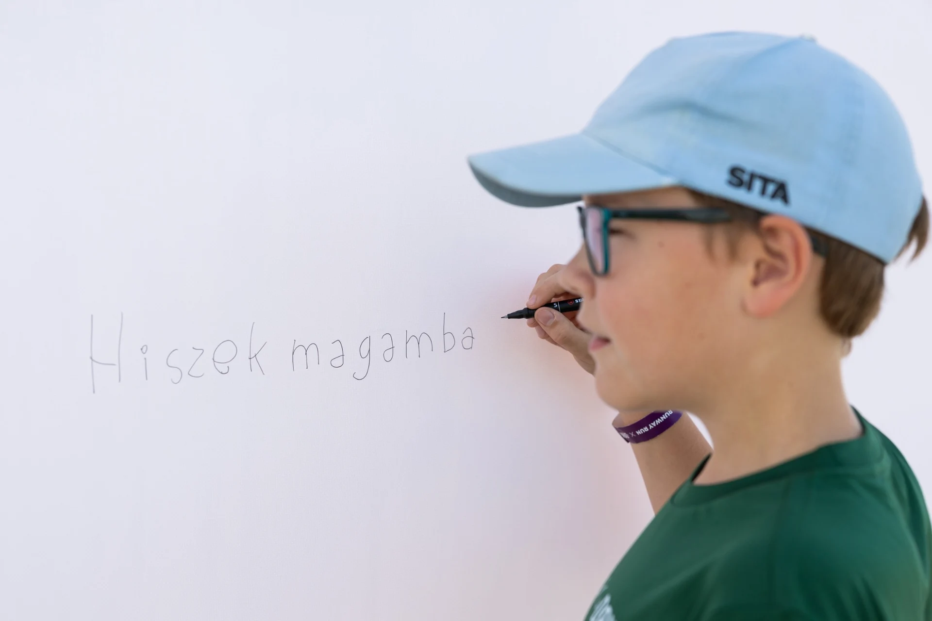 SITA-sapkás kisgyerek üzenetet ír a rendezvény üzenőfalára